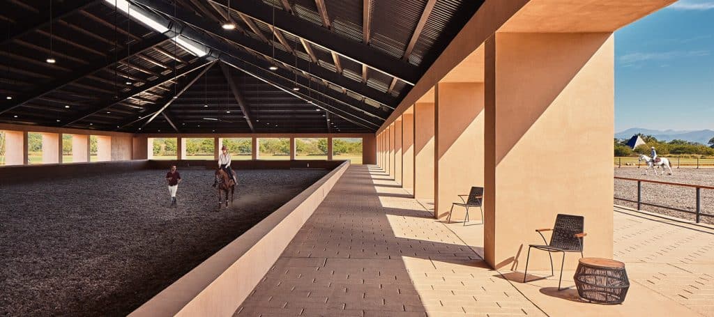 instruction gives horseback riding lesson to girl in open-air arena