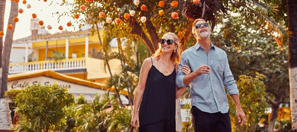 couple walks through sayulita with arms linked