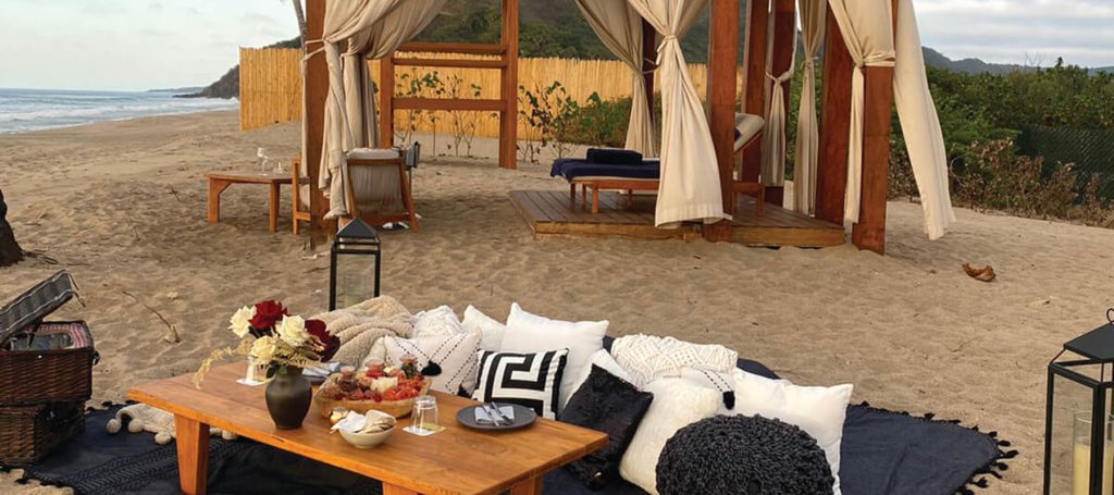 picnic setting on beach during sunset overlooks ocean
