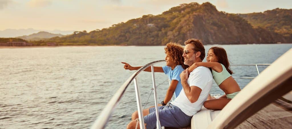 kids hug dad as they whale watch at mandarina