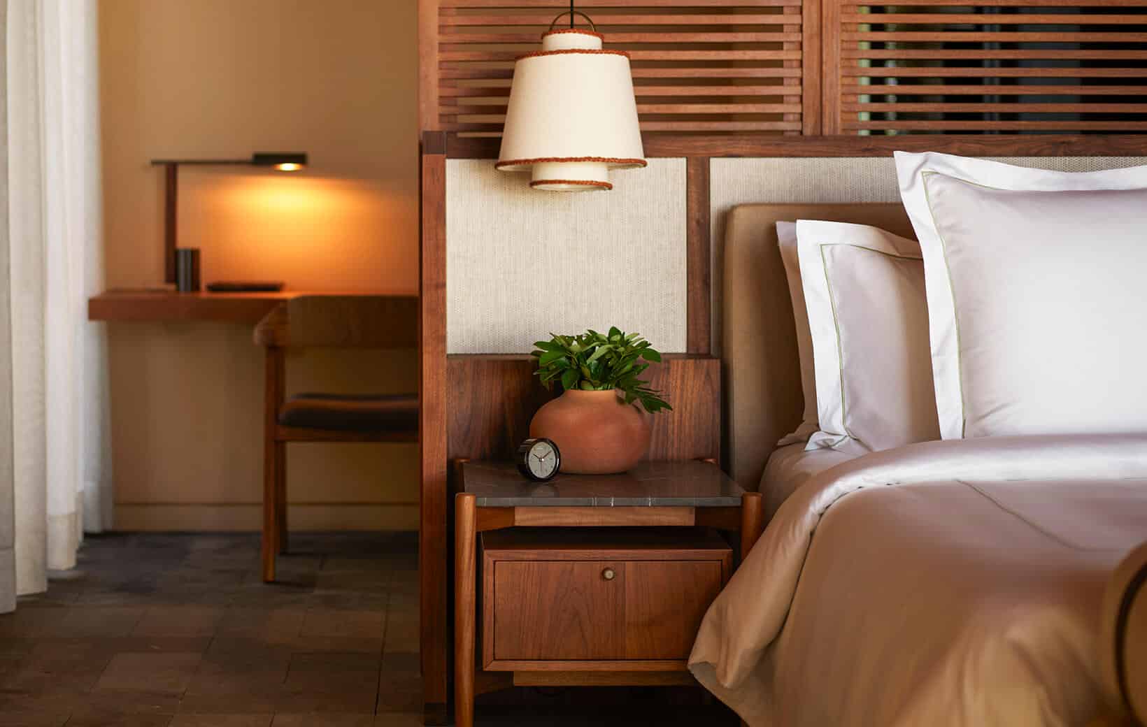 hotel room bed with bathroom behind the headboard