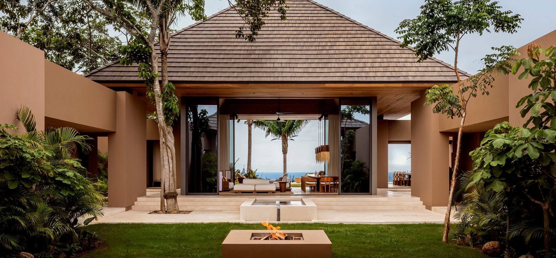 courtyard with fireplace looks through living area and ocean views