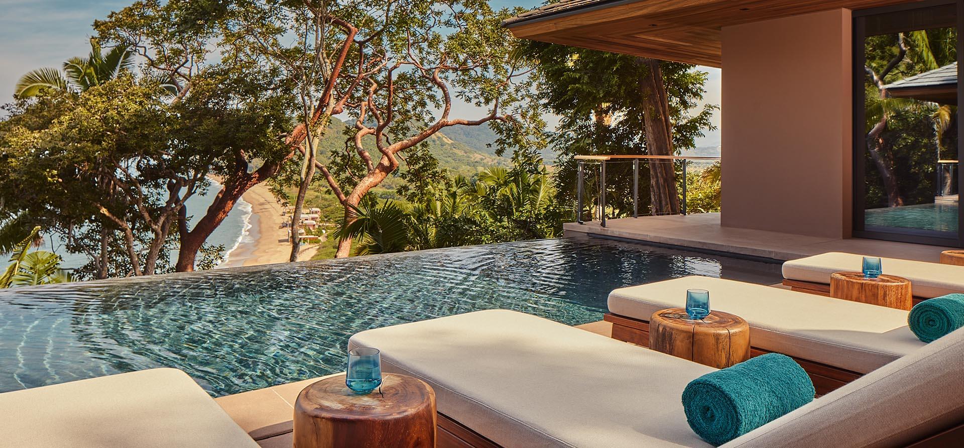 infinity pool overlooks cliff-side ocean and beach at mandarina