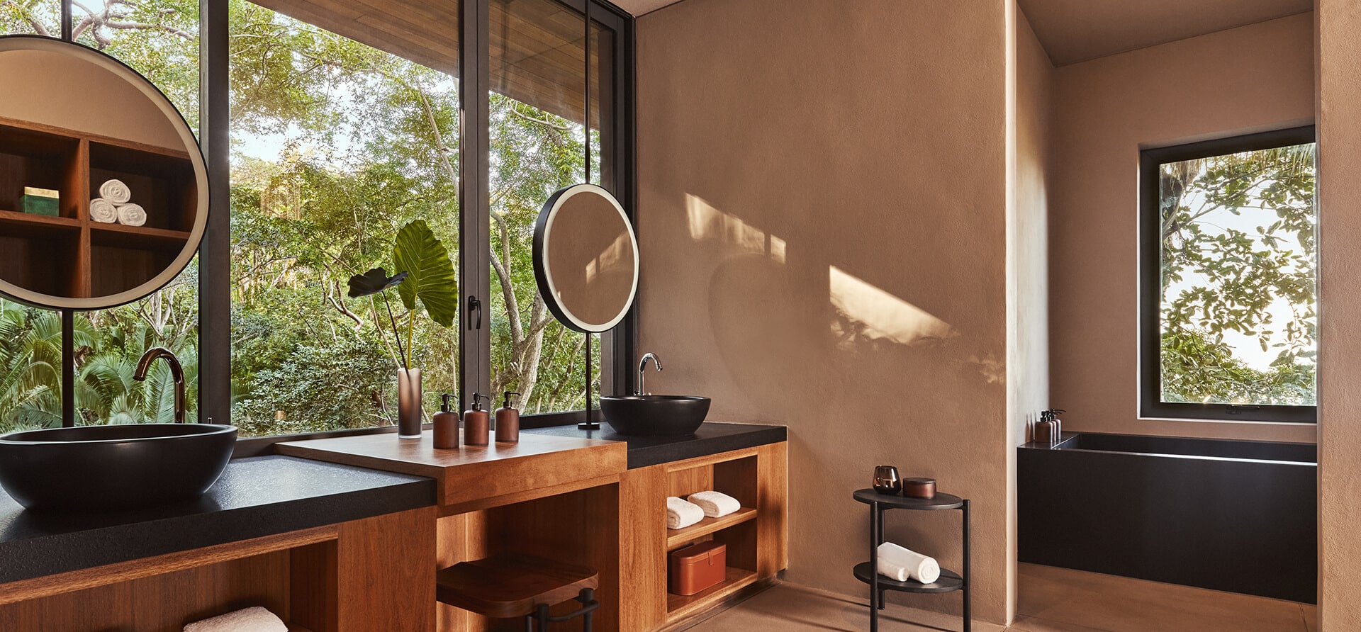 bathroom vanity with windows surrounding to show jungle views